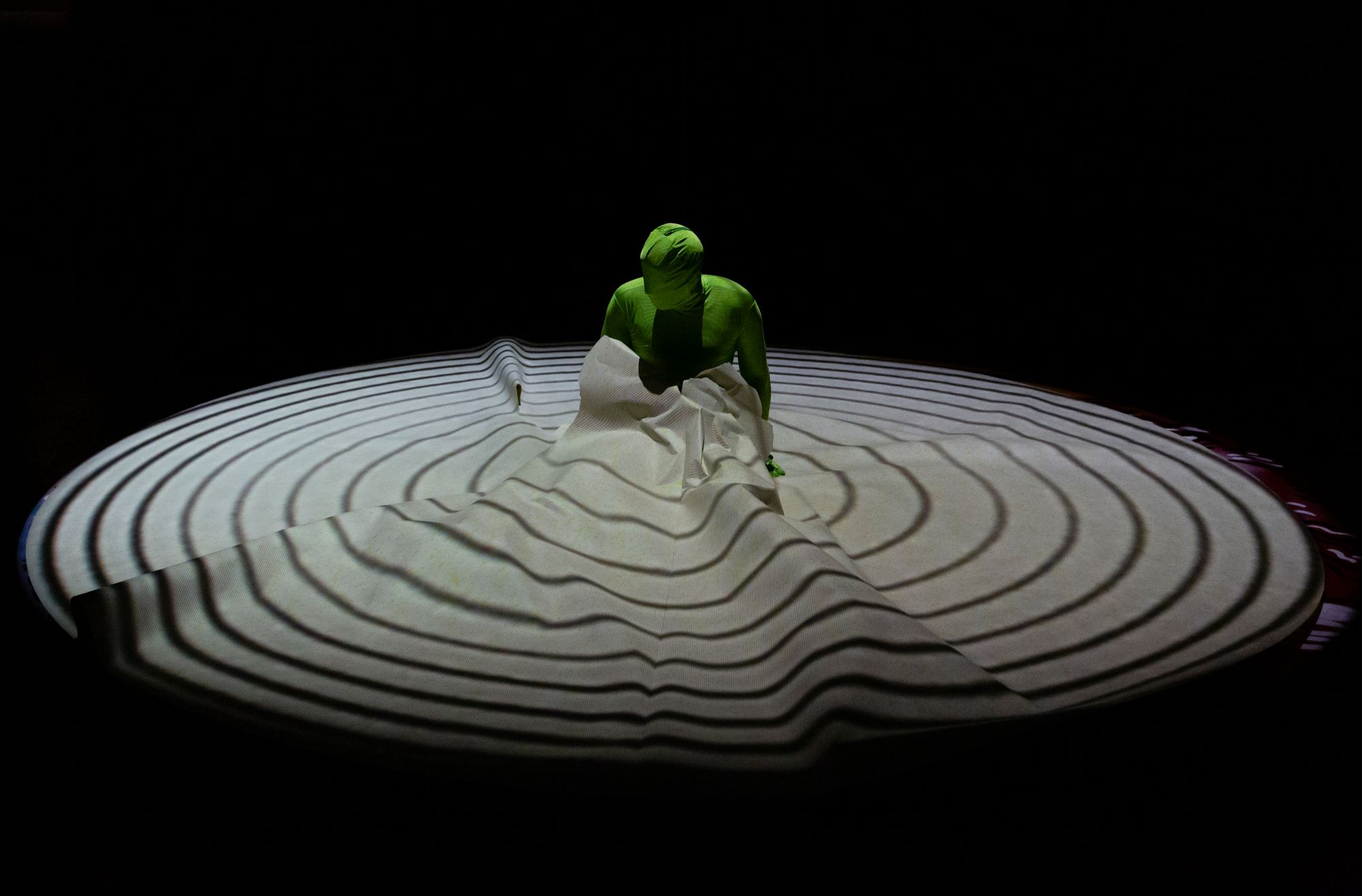 A performer in a green suit on a stage